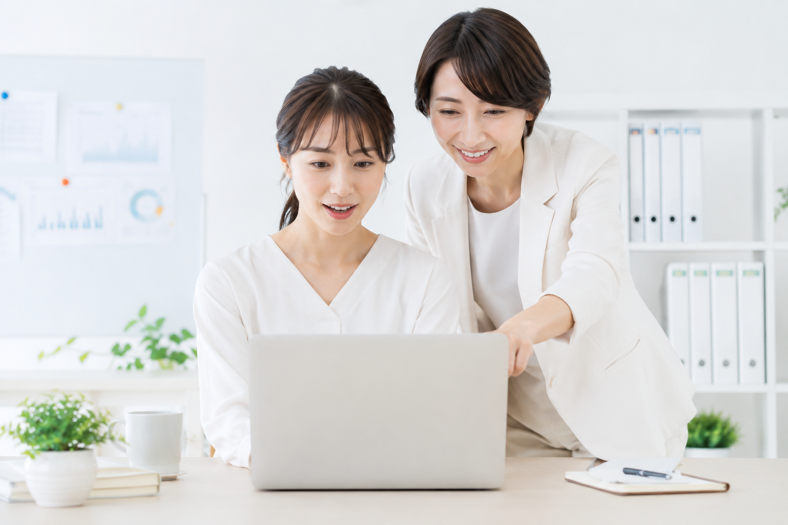 パソコンを見ながら資産運用について相談する女性たち